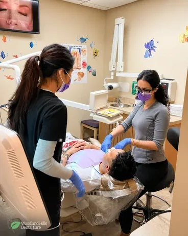 Dentist in Canoga Park providing dental treatment with clinical support in a modern dental care setting